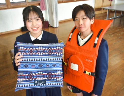 ライフジャケットを持つ児童